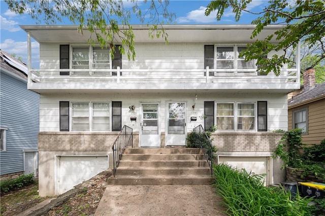 3525-3527 Bell St, Kansas City, MO 64111 - townhome / multi-family property with a garage, brick siding, entry steps, and a balcony