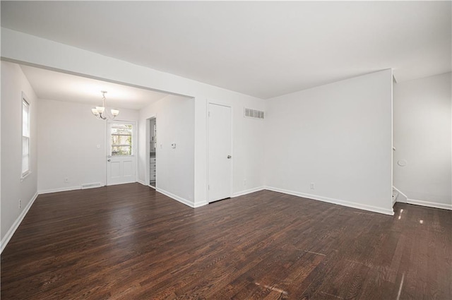 3525-3527 Bell St, Kansas City, MO 64111 - empty room with a chandelier, visible vents, dark wood-style flooring, and baseboards