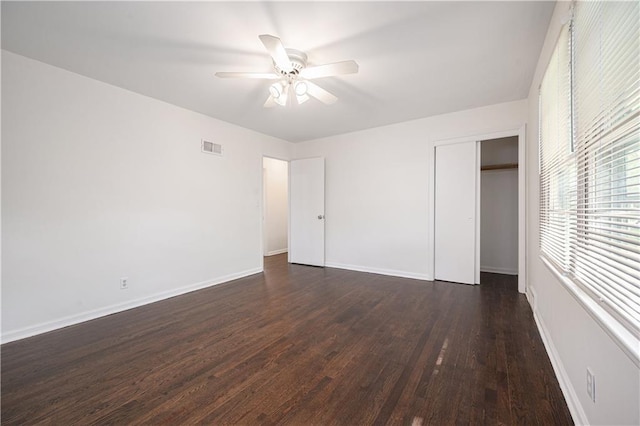 3525-3527 Bell St, Kansas City, MO 64111 - unfurnished bedroom featuring a closet, visible vents, a ceiling fan, dark wood-style floors, and baseboards