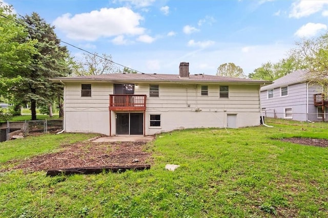 rear view of property featuring a yard, fence, and a chimney