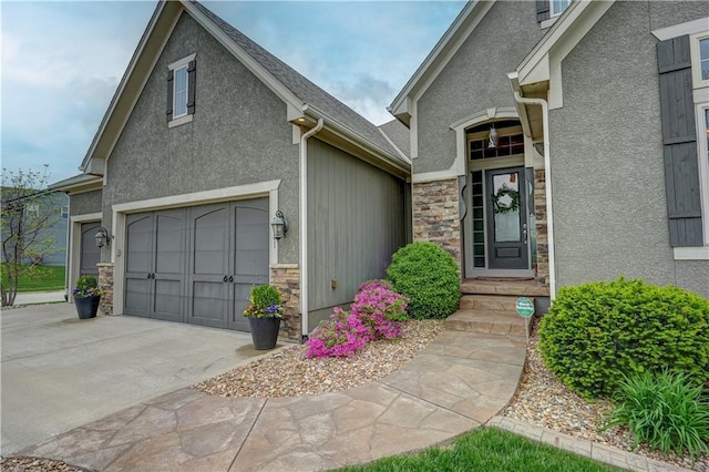 property entrance with stucco siding, driveway, and stone siding
