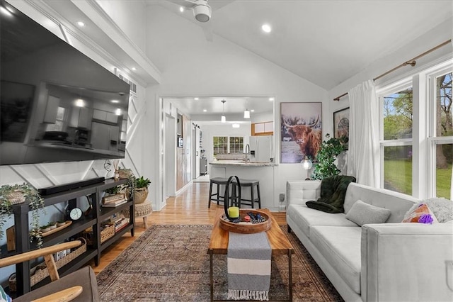 living room with recessed lighting, high vaulted ceiling, and wood finished floors