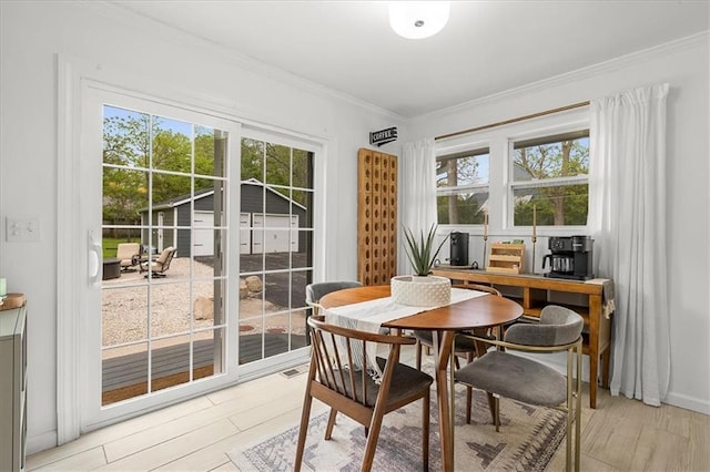 interior space with plenty of natural light, ornamental molding, and light wood-type flooring