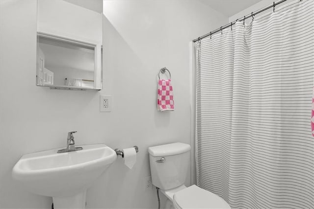 full bath with a sink, a shower with shower curtain, and toilet