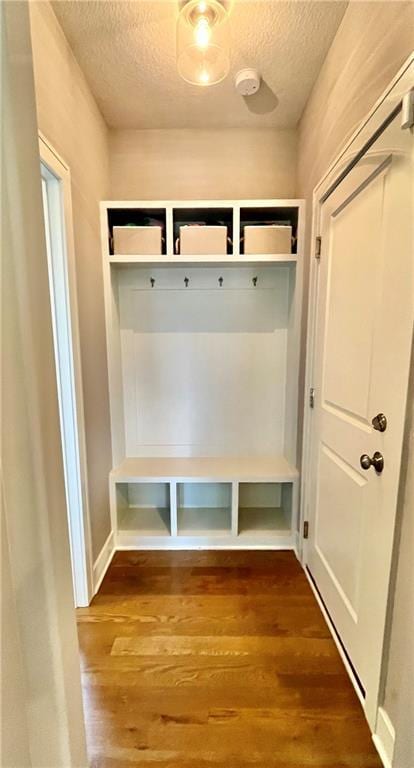 mudroom featuring a textured ceiling and dark wood finished floors