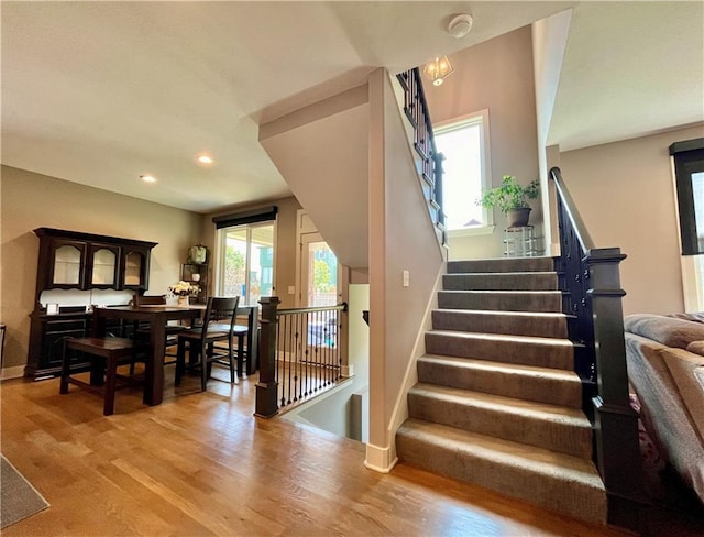 stairs with recessed lighting, baseboards, and wood finished floors