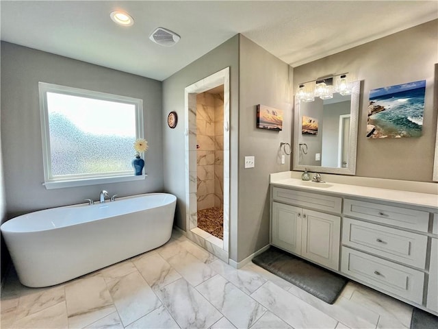 bathroom with vanity, marble finish floor, recessed lighting, a freestanding bath, and a tile shower