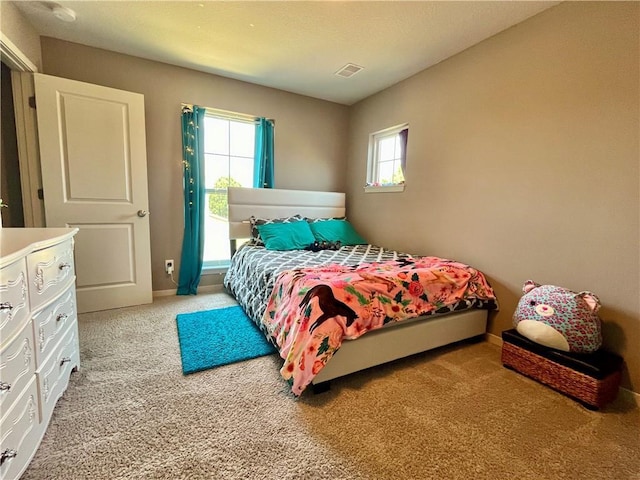 bedroom featuring baseboards, light carpet, and visible vents