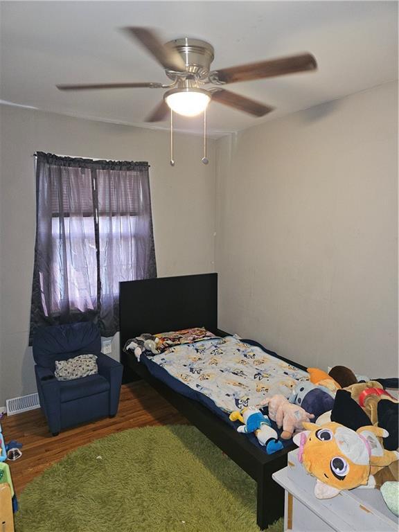 8212 NE 51st St, Kansas City, MO 64119 - bedroom featuring a ceiling fan, wood finished floors, and visible vents