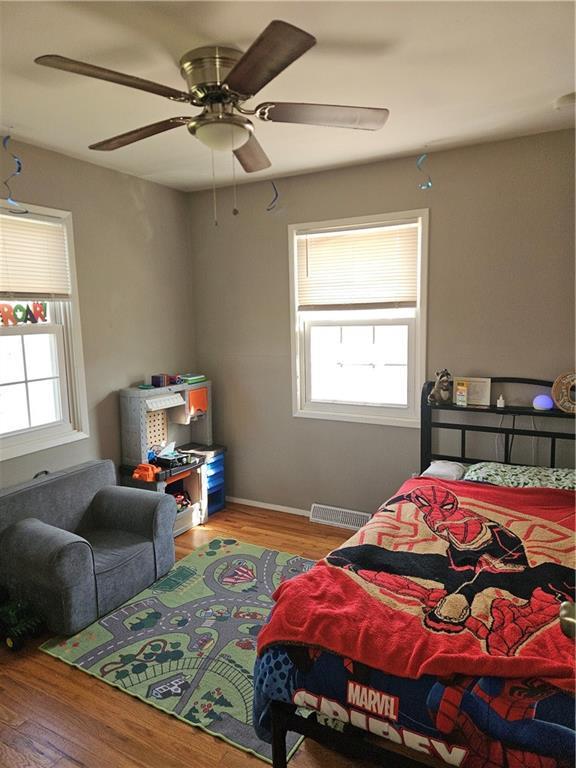 8212 NE 51st St, Kansas City, MO 64119 - bedroom with baseboards, ceiling fan, visible vents, and wood finished floors