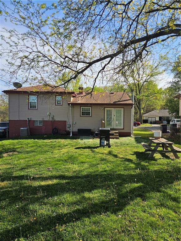 8212 NE 51st St, Kansas City, MO 64119 - back of property featuring french doors, central AC, and a yard