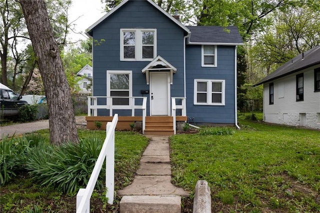 view of front of home featuring roof with shingles and a front lawn