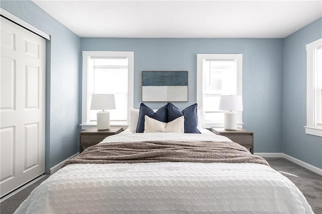 bedroom featuring baseboards and dark colored carpet