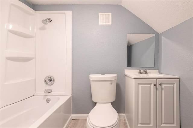bathroom with visible vents, vaulted ceiling, vanity, toilet, and washtub / shower combination