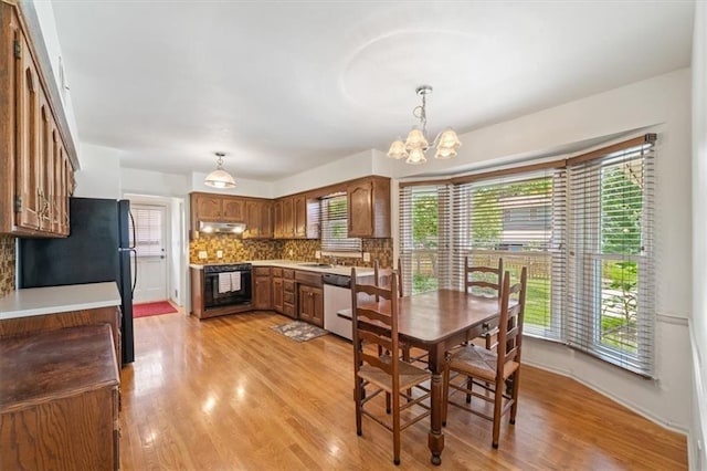 4071 SW Royale Ct, Lees Summit, MO 64082 - dining space featuring light wood-style floors, a chandelier, and healthy amount of natural light