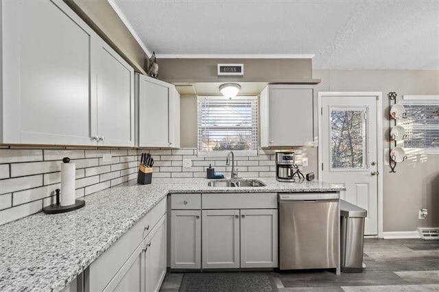 kitchen featuring backsplash, a textured ceiling, a sink, and dishwasher