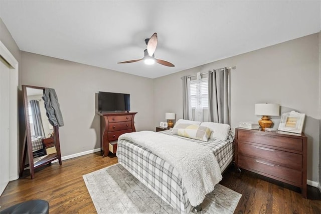 bedroom featuring a closet, baseboards, a ceiling fan, and dark wood-type flooring