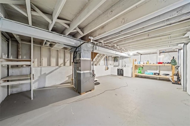 unfinished basement featuring heating unit and washing machine and dryer