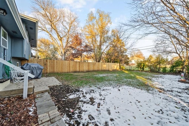 yard layered in snow featuring a patio and a fenced backyard