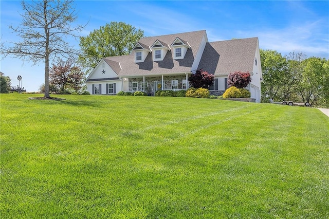 new england style home featuring an attached garage, stone siding, and a front yard