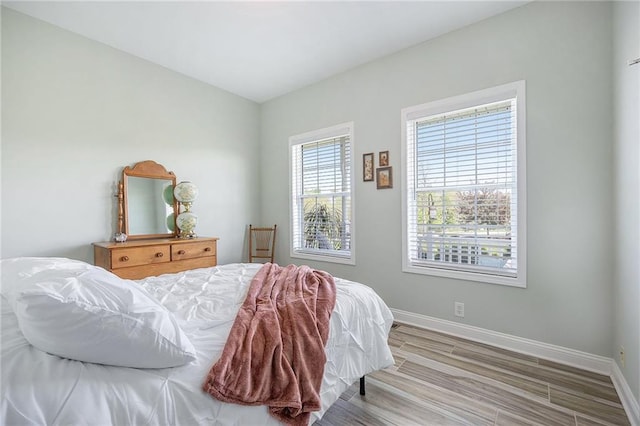 bedroom with baseboards and wood finished floors