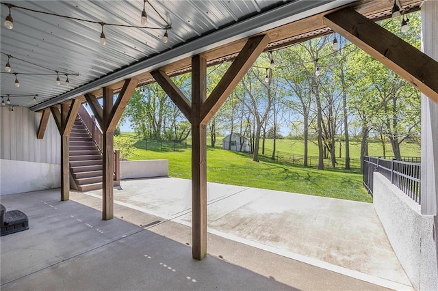 view of patio / terrace with stairway, fence, and an outdoor structure