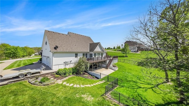 rear view of property with a fenced backyard, a yard, a deck, and stairway