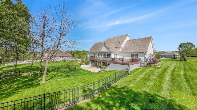 rear view of house with a lawn, a deck, and a fenced backyard