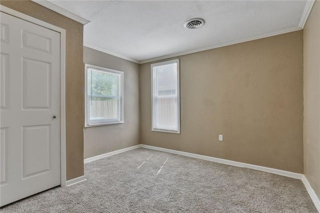 unfurnished room featuring ornamental molding, carpet, baseboards, and a textured ceiling