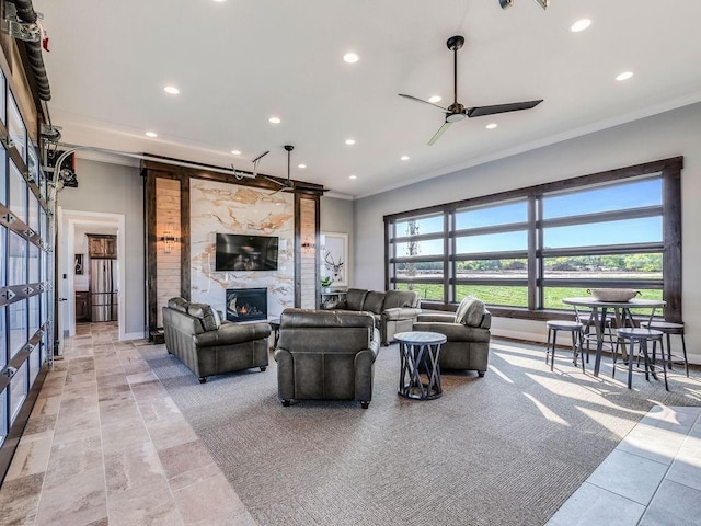 living room with crown molding, a large fireplace, ceiling fan, and recessed lighting