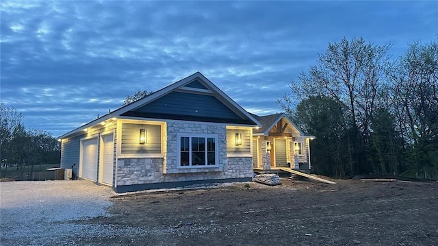 9410 Deer Run St, Lenexa, KS 66220 - view of front of home featuring stone siding, an attached garage, driveway, and central AC