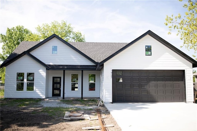 1927 E Sixth St, Sedalia, MO 65301 - modern inspired farmhouse with a shingled roof, a porch, and driveway