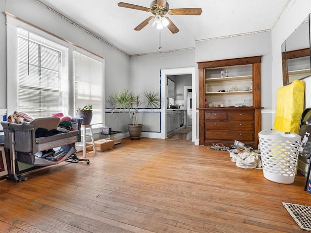 living area featuring wood-type flooring and a ceiling fan