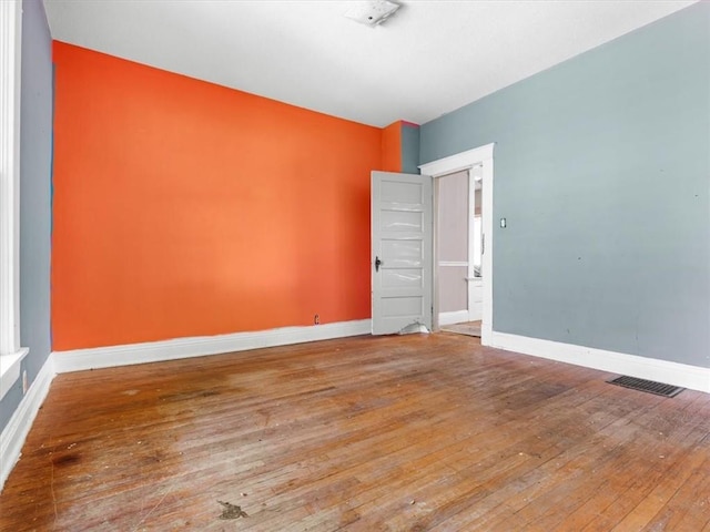 empty room with hardwood / wood-style floors and baseboards