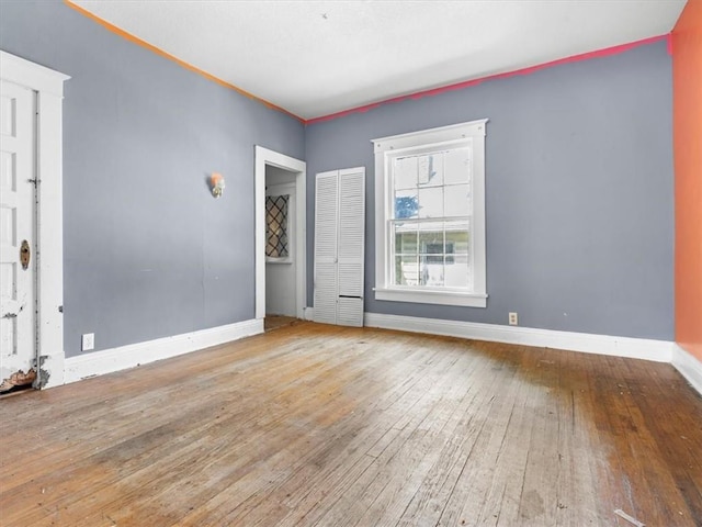 spare room featuring hardwood / wood-style flooring and baseboards