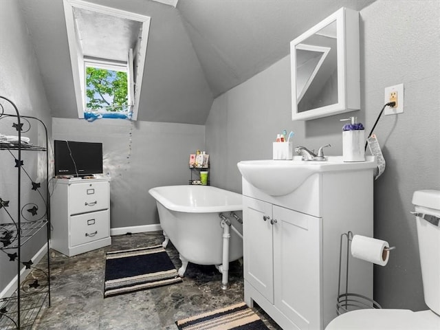 full bath featuring vaulted ceiling, a freestanding tub, vanity, baseboards, and toilet