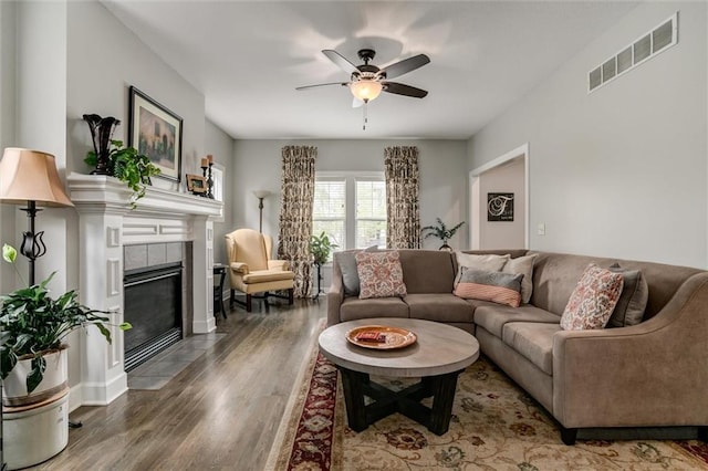 925 SW Ovation Dr, Lees Summit, MO 64081 - living room with visible vents, wood finished floors, baseboards, a tile fireplace, and a ceiling fan