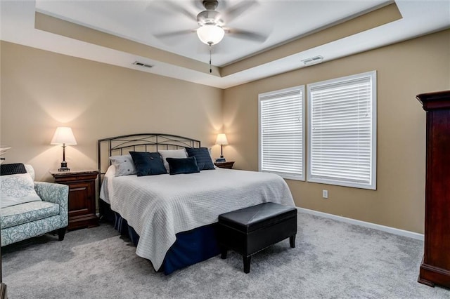925 SW Ovation Dr, Lees Summit, MO 64081 - bedroom featuring a tray ceiling, visible vents, light carpet, and baseboards