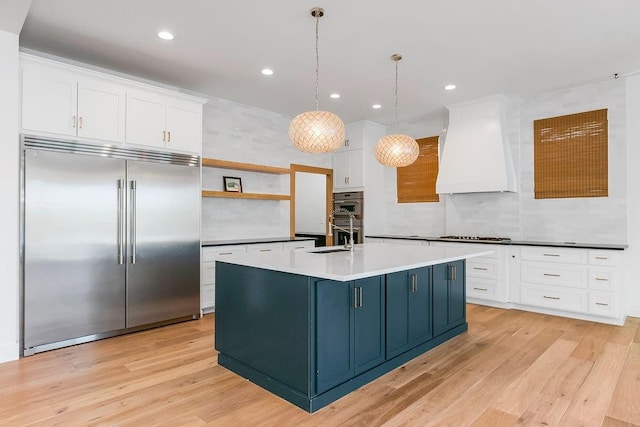 kitchen with open shelves, light wood finished floors, stainless steel appliances, white cabinetry, and custom exhaust hood