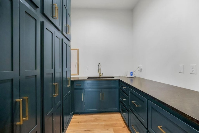 bar with a sink and light wood finished floors