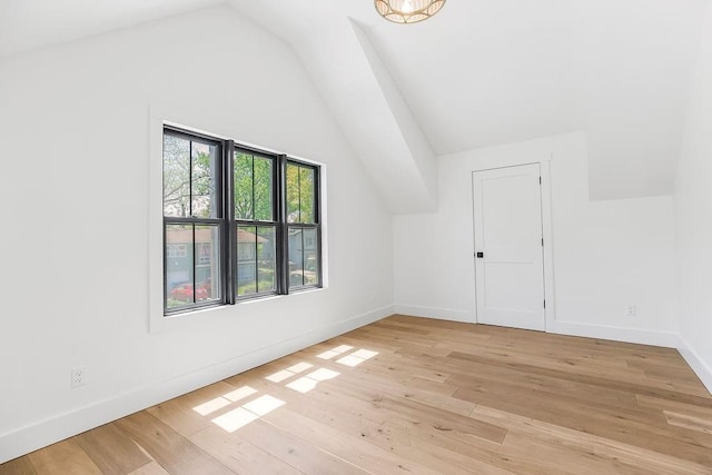 bonus room featuring baseboards, vaulted ceiling, and light wood finished floors