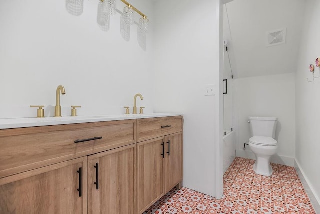 bathroom with a sink, toilet, double vanity, and visible vents