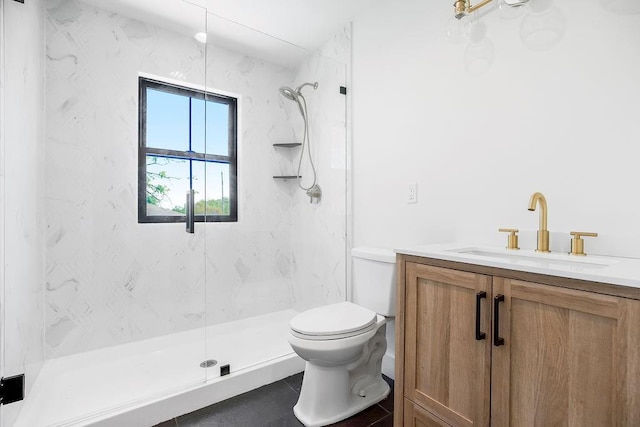 bathroom with toilet, a marble finish shower, tile patterned flooring, and vanity