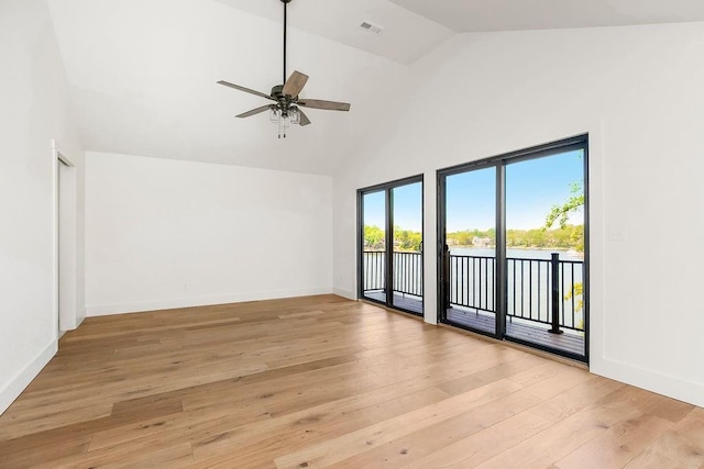 unfurnished room featuring light wood-style floors, high vaulted ceiling, a ceiling fan, baseboards, and a water view