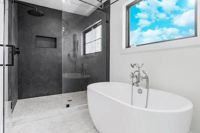 bathroom featuring a walk in shower and a freestanding bath