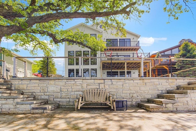 back of house featuring stairs and a balcony