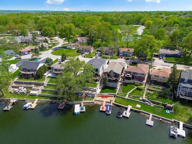 drone / aerial view featuring a water view, a residential view, and a forest view