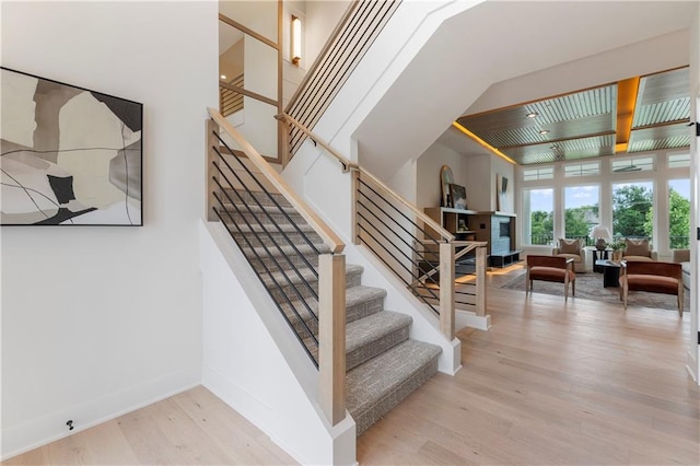 10675 W 142nd Ter, Overland Park, KS 66221 - staircase with wood finished floors, a fireplace, and beamed ceiling