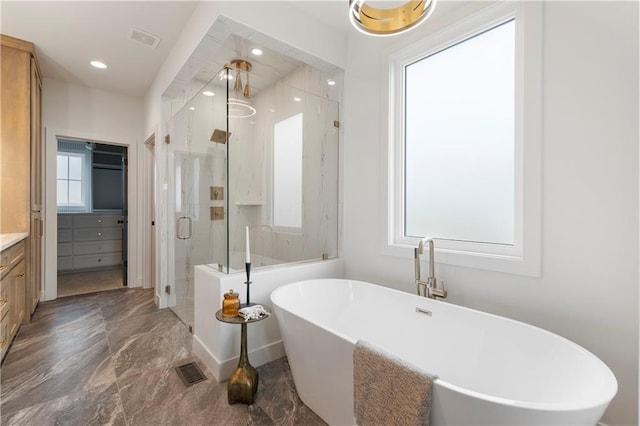 10675 W 142nd Ter, Overland Park, KS 66221 - bathroom featuring vanity, a stall shower, marble tiled floors, a freestanding tub, and recessed lighting