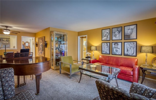living room with a ceiling fan and carpet
